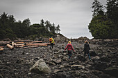 Full length rear view of father and daughters hiking through rocks