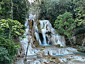 Luftaufnahme des Kuang-Si-Wasserfalls, umgeben von üppigem Wald und ruhigem Grün, Bezirk Luang Prabang, Luang Prabang, Laos.