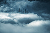Luftaufnahme der majestätischen, in Nebel gehüllten Alpen mit heiteren Bäumen und Wolken, Amden, St. Gallen, Schweiz.