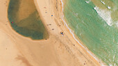 Aerial view of Sotavento beach with golden sand, clear water, and sunbathing people, Fuerteventura Island, Canary Islands, Spain.