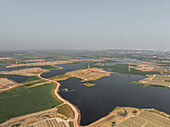 Aerial view of brick fields and factory amidst beautiful landscape and water, Kaundia, Savar, Dhaka, Bangladesh.