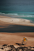 Aerial view of beautiful sandy beach with lifeguard tower and tranquil ocean waves, Playa de la Pared, Fuerteventura, Canary Islands, Spain.
