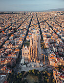 Aerial view of the iconic Basilica de la Sagrada Familia amidst a vibrant cityscape, Barcelona, Catalonia, Spain.