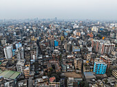 Aerial view of vibrant cityscape with high-rise buildings and bustling streets at sunset, Sadar Ghat, Sutrapur Thana, Dhaka, Bangladesh.