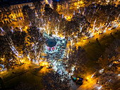 Aerial view of festive lights illuminating a vibrant city park filled with a crowd during the advent season, Zagreb, Croatia.