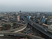 Luftaufnahme einer belebten Kreuzungsstraße und eines Busbahnhofs, umgeben von modernen Gebäuden und Fahrzeugen, Gendaria, Dhaka, Bangladesch.