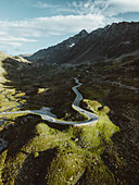 Aerial view of beautiful alpine landscape with winding road and majestic mountains, Davos, Kanton Graubunden, Switzerland.