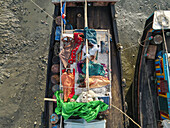 Chittagong, Bangladesh - 10 September 2022: Aerial view of fishermen resting on wooden boats along the serene Karnaphuli River, Chittagong, Bangladesh.