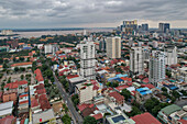 Luftaufnahme einer städtischen Skyline mit Hochhäusern und einem Fluss unter bewölktem Himmel, Daun Penh District, Phnom Penh, Kambodscha.