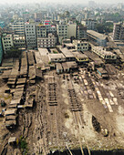 Luftaufnahme einer industriellen Werft mit Booten und städtischen Gebäuden, Subhadya, Keraniganj, Dhaka, Bangladesch.