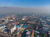 Luftaufnahme einer Stadtlandschaft mit Gebäuden und Brandrauch im Bokor-Gebirge, Kampong Bay, Tuek Chhou District, Kampot, Kambodscha.