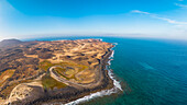 Aerial view of rugged volcanic coast and serene ocean, Lobos Island, Canary Islands, Spain.
