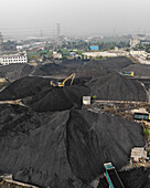 Aerial view of coal factory with cranes and machinery amidst coal piles, Amin Bazar, Savar, Dhaka, Bangladesh.