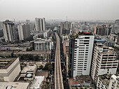 Aerial view of bustling city skyline with modern skyscrapers and railway infrastructure, Paltan Thana, Dhaka, Bangladesh.