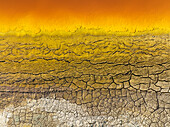 Luftaufnahme von einzigartigen rissigen Erdmustern in leuchtenden Farben wie Gelb, Orange und Braun, Rio Tinto, Huelva, Spanien.