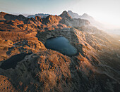 Aerial view of serene alpine landscape with majestic mountains and a tranquil lake at sunset, Sils, Kanton Graubunden, Switzerland.