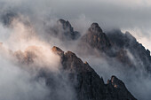 Luftaufnahme von majestätischen Dolomiten und schroffen Gipfeln, die in Wolken und Nebel gehüllt sind, Auronzo di Cadore, Provinz Belluno, Italien.