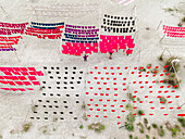 Aerial view of vibrant hand-dye fabrics drying in rows at a factory, Narayanganj, Dhaka, Bangladesh.