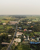 Luftaufnahme eines schönen ländlichen Dorfes, umgeben von grünem Ackerland und Feldern mit einer Straße, Duptara, Araihazar, Dhaka, Bangladesch.
