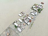 Aerial view of submerged and waterlogged village with floating homes amidst rising waters and flooded streets, Kurigram, Kurigram, Bangladesh.