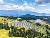 Aerial view of idyllic landscape with wind turbines and solar panels amidst mountains and trees, Lachtal, Styria, Austria.