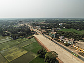 Luftaufnahme von ländlichem Ackerland und Dorfleben mit Reisfeldern und Grünflächen, Putia, Shibpur, Dhaka, Bangladesch.