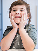 A child plays happily with flour on his face and wears an apron. The scene captures the happiness and creativity that arise when baking.