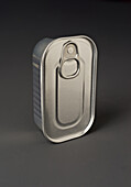A shiny, closed metal food tin stands upright on a grey surface. The tin is designed for food storage and has a pull tab at the top for easy opening, emphasising its practicality and durability.