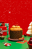 A delicious panettone surrounded by lively Christmas decorations, gifts, jewellery and a festively laid table that radiates warmth and joy.