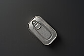 Top view of a closed aluminium food can with a pull tab on a grey background. The minimalist composition emphasises simplicity and industrial design.