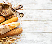 Assortment of baked bread on a white wooden background