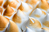 Detailed close-up of perfectly toasted meringue tips, showing off their golden brown colour and soft white texture. Ideal for culinary and dessert-related projects.