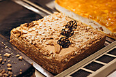 A shop window displays a tantalising selection of pastries, including layer cakes with creamy toppings and chocolate decorations - perfect for a sweet treat