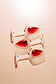 Three red wine glasses stand on a flat surface and cast fascinating reflections. The play of light and shadow creates an artistic composition that is perfect for wine-related content.