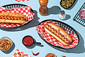 Overhead shot of hot dogs in baskets, served with ketchup and mustard on a bright blue background