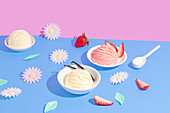 Vibrant, split background in pink and blue, on which various flavours of ice cream are presented. The scene contains decorative elements such as flowers and fruit slices, which are aesthetically arranged.