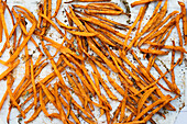 This picture shows crispy sweet potato sticks that are baked, seasoned and served as a tasty and visually appealing snack option