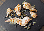 Close-up of pieces of grilled rabbit with caramelised onions, served on a black slate The roasted meat, paired with the aromatic onions, offers a gourmet presentation