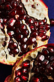 Close-up of bright pomegranate seeds, highlighting the rich red colour and juicy, glossy texture. The image captures the natural beauty and freshness of the fruit.