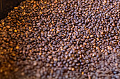Close-up of a textured stack of freshly roasted coffee beans The rich brown tones highlight the intricate details and capture the essence of coffee's aromatic appeal