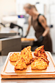 Freshly baked Italian pastries lie on a wooden board in a warm bakery A baker works in the background, creating a cosy and authentic Italian atmosphere
