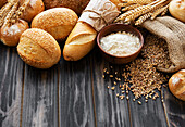Assortment of baked bread on an old wooden background