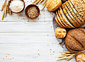 Assortment of baked bread on a white wooden background