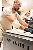 Skilled bakers work in an Italian bakery and prepare the dough for fresh pastries The warm, inviting atmosphere of the kitchen emphasises the art of traditional baking