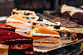 A colourful display of different desserts with cakes and pastries in the window of a patisserie Rich textures and colours make for an inviting and delicious presentation