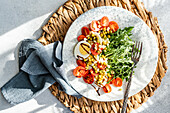 Köstlicher und nahrhafter Keto-Salat mit gekochten Eiern, frischem Rucola, Kirschtomaten, grünen Erbsen aus der Dose und gekeimten grünen Bohnen, alles mit Balsamico-Sauce beträufelt.