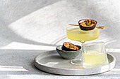 A sophisticated gin and tonic cocktail, paired with the exotic flavour of passion fruit juice, garnished with a fresh passion fruit half.