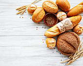 Assortment of baked bread on a white wooden background