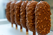 Close-up of chocolate-covered gelato bars on a stick, reminiscent of ice cream These delicious treats are part of Italian bakery and dessert culture and appeal to sweet lovers