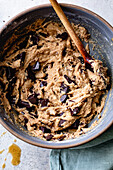 A bowl of biscuit dough mixed with dark chocolate chips, ready to bake.
